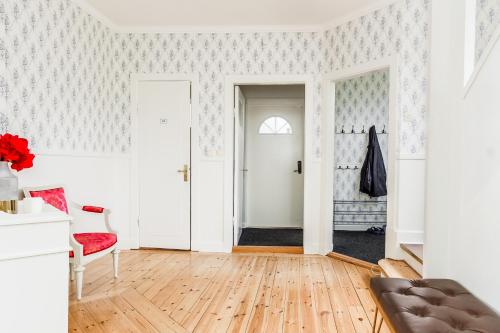 a living room with white walls and wood floors at Central Lakefront Retreat in Hagfors