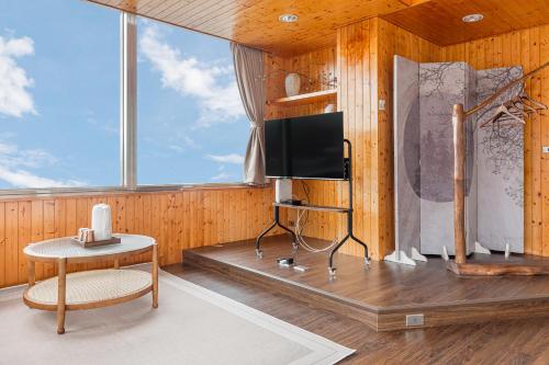 a room with a tv and a chair and a table at Jiufen Nostalgic Inn in Jiufen