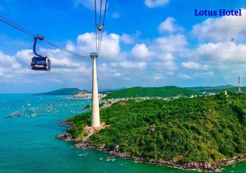 a gondola flying over a island with a lighthouse at Lotus Phú Quốc Hotel in Phu Quoc