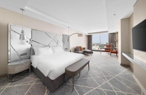 a hotel room with a bed and a living room at Radisson Blu Hotel and Convention Center, Riyadh Minhal in Riyadh