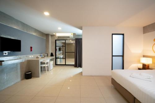 a hotel room with a bed and a bathroom at The Riche Boutique Hotel Don Mueang Airport in Bangkok
