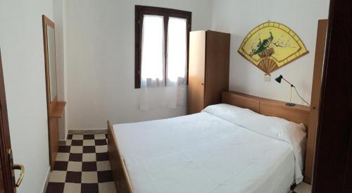 サンタ・テレーザ・ガッルーラにあるCase Vacanze Di Jakiのチェックフロアのベッドルーム1室(ベッド1台付)