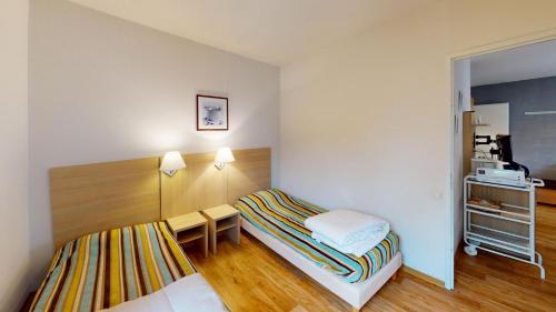 Cette petite chambre comprend un lit et une petite table. dans l'établissement Apartamento Jardins de Ramel, à Luchon