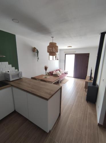 a kitchen and living room with a couch and a table at Casa rural La Pinada in Villanueva de Viver