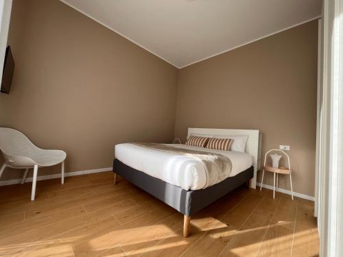 a bedroom with a bed and a chair at Leonardo 20 in Muggiò