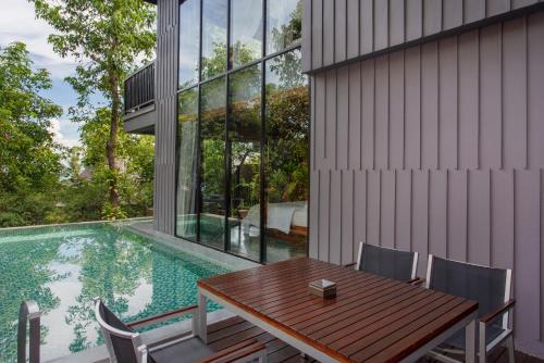 a dining room with a table and chairs and a swimming pool at Silavadee Pool Spa Resort - SHA Extra Plus in Lamai