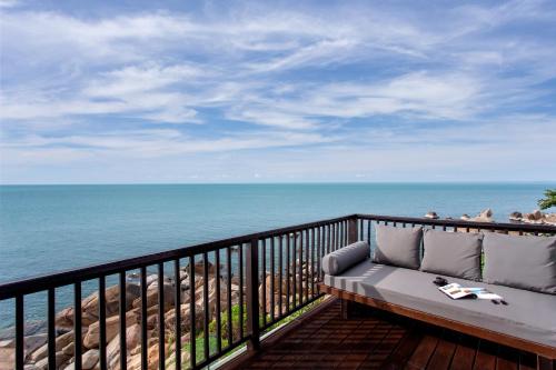 a couch sitting on a balcony overlooking the ocean at Silavadee Pool Spa Resort - SHA Extra Plus in Lamai
