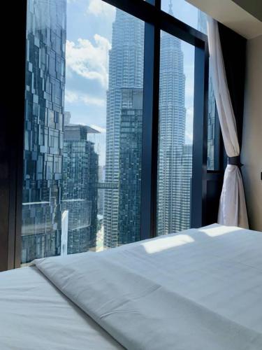 a bed in a room with a view of a city at Star KLCC by Arman in Kuala Lumpur