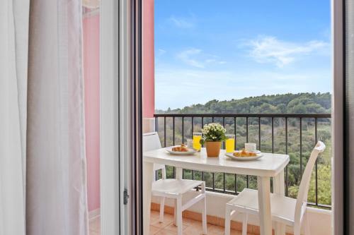 a balcony with a white table and chairs and a view at Residence Kamenjak in Premantura