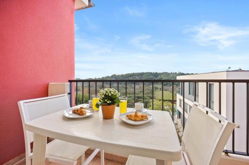 a white table with two plates of food on a balcony at Residence Kamenjak in Premantura
