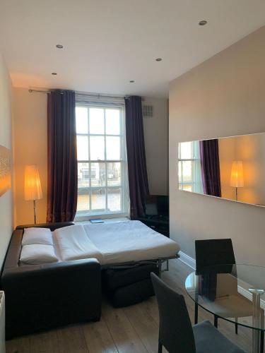 a bedroom with a bed and a large window at Temple Bar Essex Apartments in Dublin