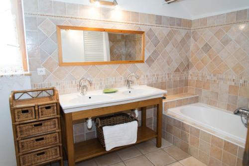 une salle de bain avec un lavabo et une baignoire dans l'établissement Gîte Gîte Le Baptistou - 7/9 personnes, à Fraissinet-de-Fourques