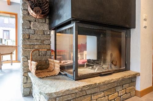 a fireplace in a living room with a brick wall at chalet pierre et bois in Aigueblanche