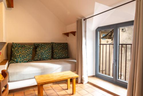 un salon avec un canapé et une fenêtre dans l'établissement Gîte Gîte Brager 2/4 personnes à Ispagnac, à Ispagnac