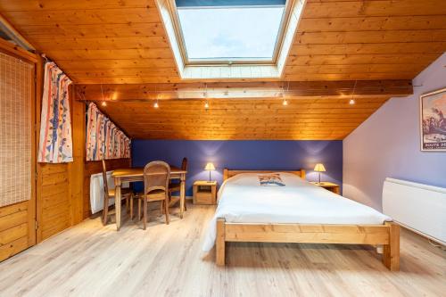 a bedroom with a bed and a table and chairs at chalet pierre et bois in Aigueblanche