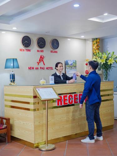a man is standing at a cash register at New An Phú Hotel in Dong Anh