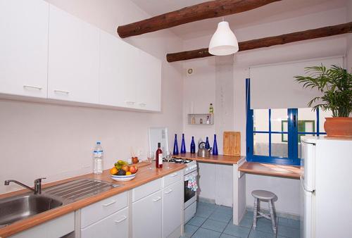 eine Küche mit weißen Schränken, einer Spüle und einer Theke in der Unterkunft Casa del Rio in Caleta de Sebo