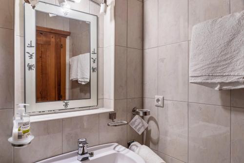 un baño con lavabo y espejo en Schwüwong - Apartment 12, en Kelchsau