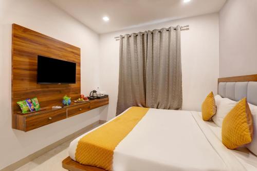 a bedroom with a bed and a television on a wall at Status By Hotel The Emporio in Ghaziabad