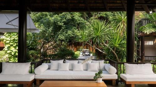 a living room with a white couch and some trees at Silavadee Pool Spa Resort - SHA Extra Plus in Lamai