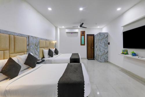 a bedroom with two beds and a flat screen tv at Status By Hotel The Emporio in Ghaziabad