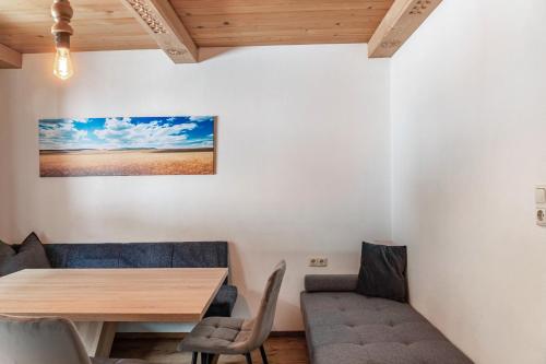 Un comedor con mesa y sillas de madera. en Schwüwong - Apartment 12, en Kelchsau