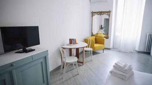 salon z telewizorem, stołem i krzesłami w obiekcie Italianway-Corso Sempione 96 w Mediolanie
