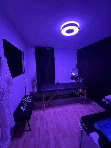 a room with a ping pong table and a purple light at L’escapade Paris spa in Vauréal
