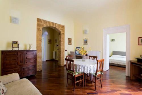 a living room with a table and chairs and a bedroom at La Casa Di Tufo in Palermo