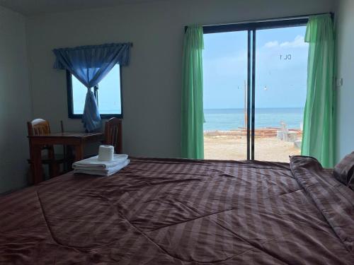 a bedroom with a bed with a view of the beach at Sunset Serenity D1 in Ko Phangan