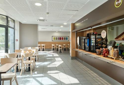 a restaurant with tables and chairs and a cafeteria at B&B HOTEL Orly Rungis Aéroport 2 étoiles in Rungis