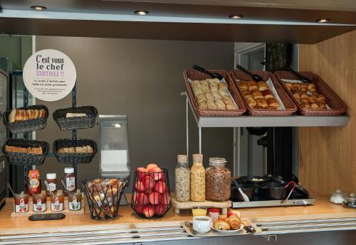 a counter with many baskets of pastries and other foods at B&B HOTEL Orly Rungis Aéroport 2 étoiles in Rungis