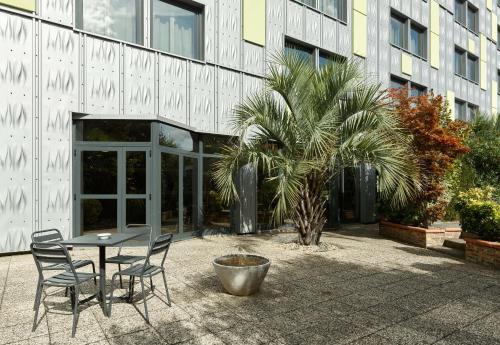a table and chairs in front of a building at B&B HOTEL Orly Rungis Aéroport 2 étoiles in Rungis