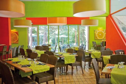 un restaurant avec des tables, des chaises et des murs verts dans l'établissement VTF Clair Canigou, à Vernet-les-Bains