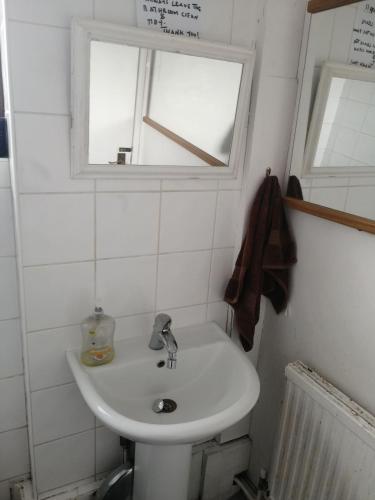 a bathroom with a white sink and a window at 42 Churchbury Rd room 1 in Eltham