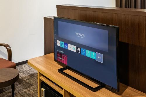 a flat screen tv sitting on top of a wooden table at HOTEL MYSTAYS PREMIER Kanazawa in Kanazawa