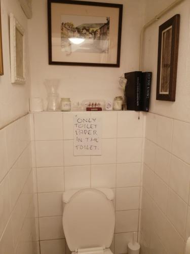 a bathroom with a toilet with a sign above it at 42 Churchbury Rd room 1 in Eltham