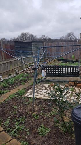 a bench sitting in a yard next to a fence at 42 Churchbury Rd room 1 in Eltham