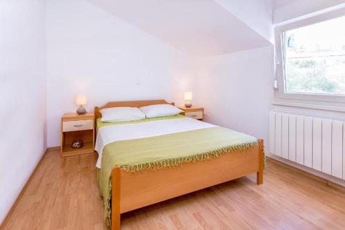 a bedroom with a bed with two night stands and a window at Cozy Nature House by Domljan Family in Omiš