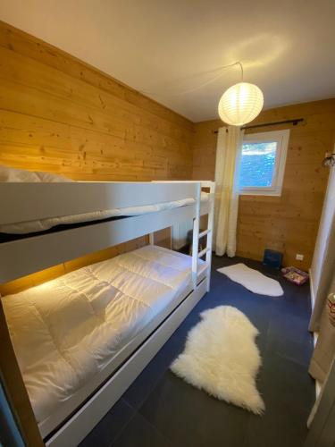 - une chambre avec des lits superposés et un tapis blanc dans l'établissement Location Appartement Valberg 3 pieces 6 a 7 personnes, à Péone