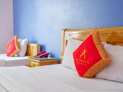 a hotel room with two beds with a red pillow at New An Phú Hotel in Dong Anh