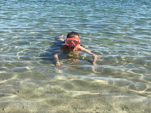 a young boy in the water with a life preserver at Mobilheim Schleistern und Schleisonne in Kappeln