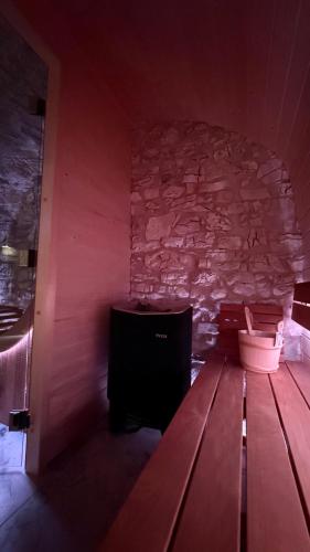 a room with a table and a stone wall at Maso K - Il Gufo Dorato in Folgaria