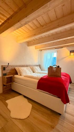 a bedroom with a large bed with a bag on it at Maso K - Il Gufo Dorato in Folgaria