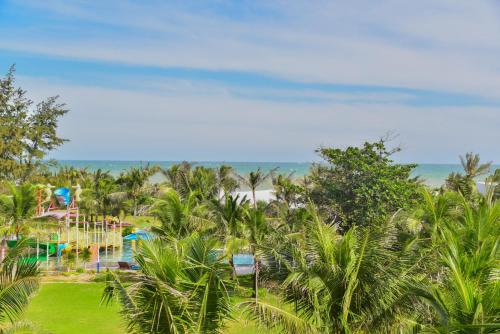 a view of a resort with a pool and a beach at The Vista Beach Resort Phan Thiết in Phan Thiet