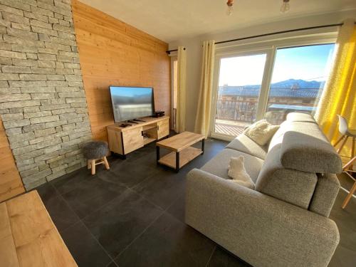 a living room with a couch and a flat screen tv at Location Appartement Valberg 3 pieces 6 a 7 personnes in Péone
