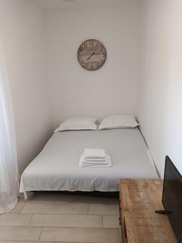 a bedroom with a bed with a clock on the wall at Stars Palace Vodice in Vodice