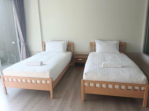 two beds in a small room with two bedsskirts at La Foresta Khaoyai in Pak Chong