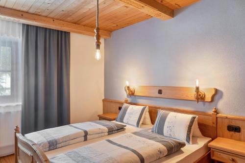 two beds in a hotel room with lights on the wall at Schwüwong - Apartment 23 in Kelchsau