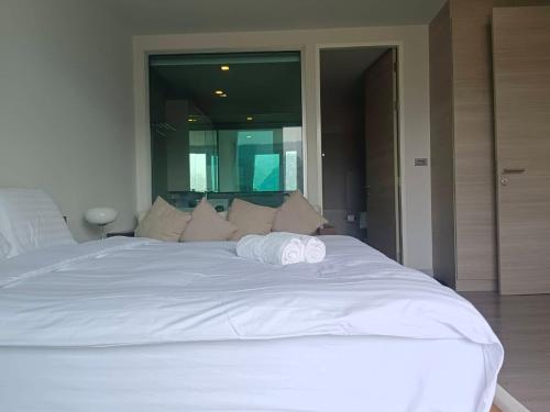a large white bed with two towels on it at La Foresta Khaoyai in Pak Chong
